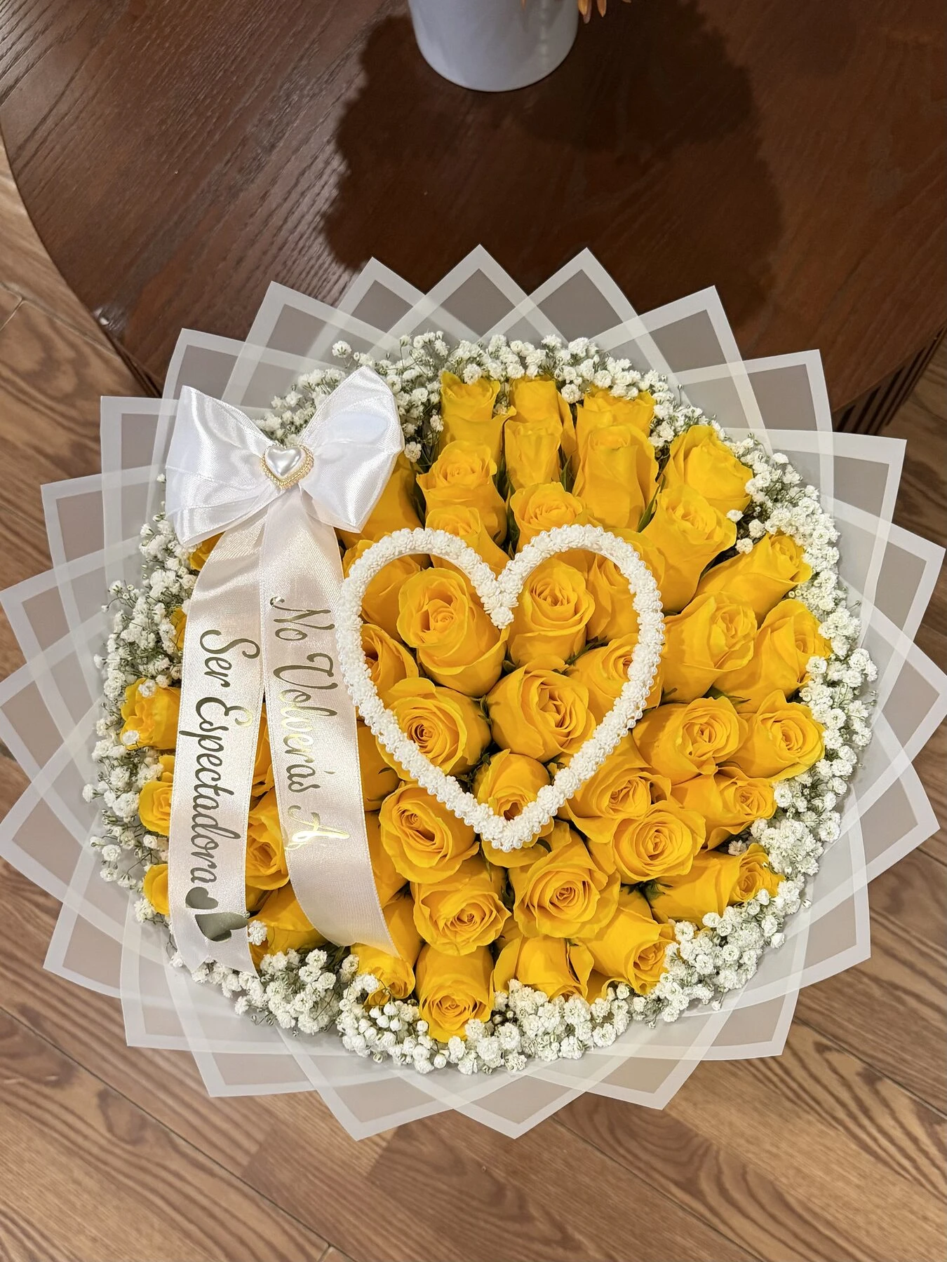Yellow rose-shaped blooms with a small white heart detail in clear layered wrapping.