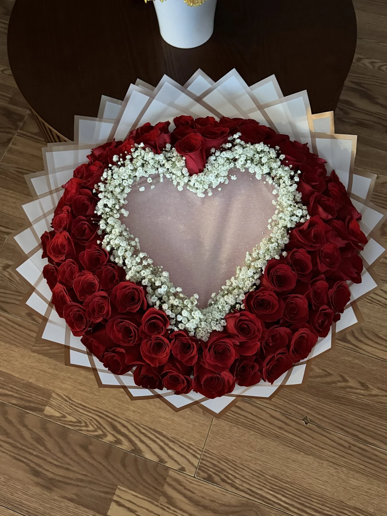 Red blooms form a ring around a pale heart-shaped center edged with small white flowers.