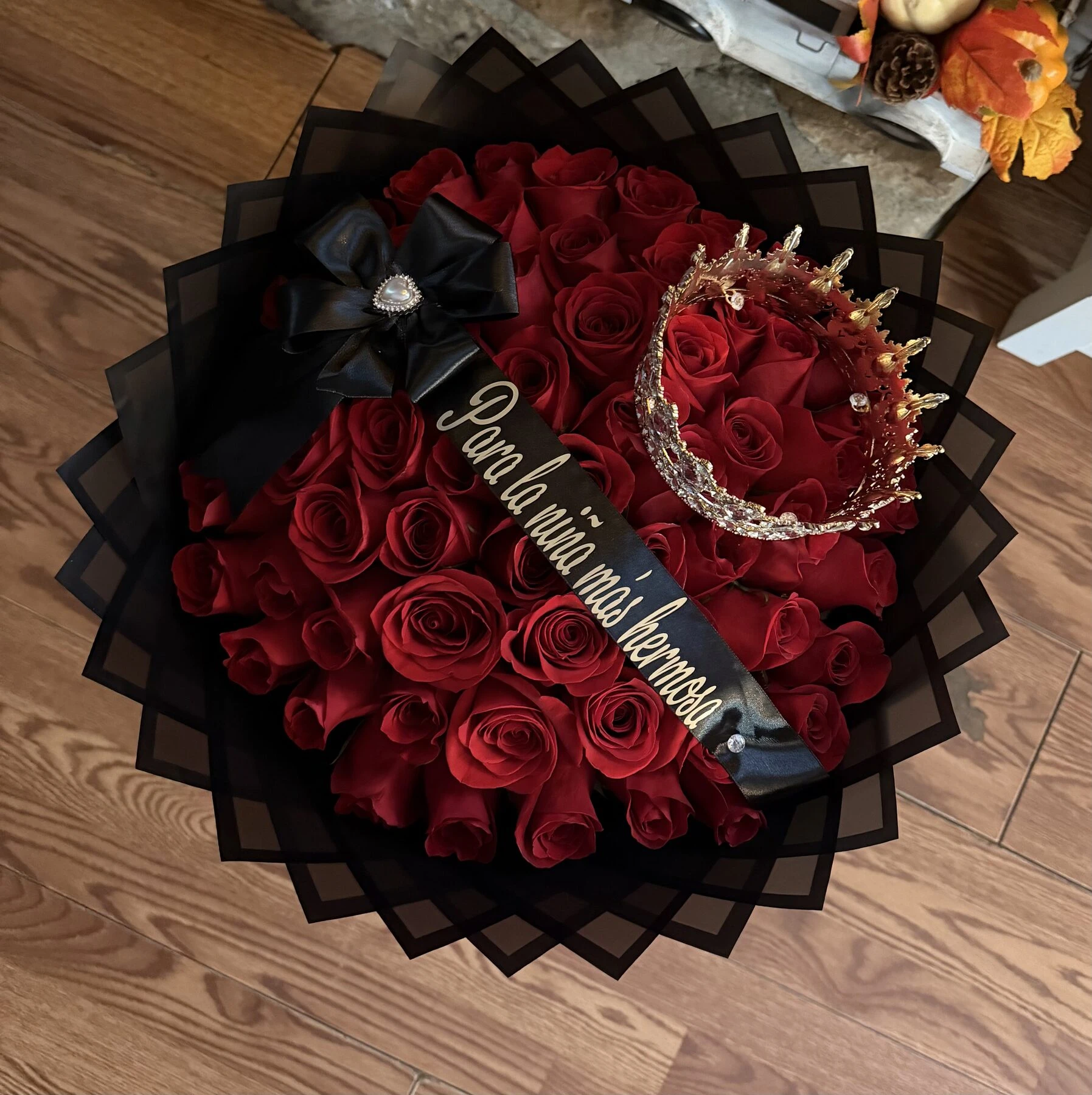 A round red floral arrangement with dark wrapping and a circular centerpiece.