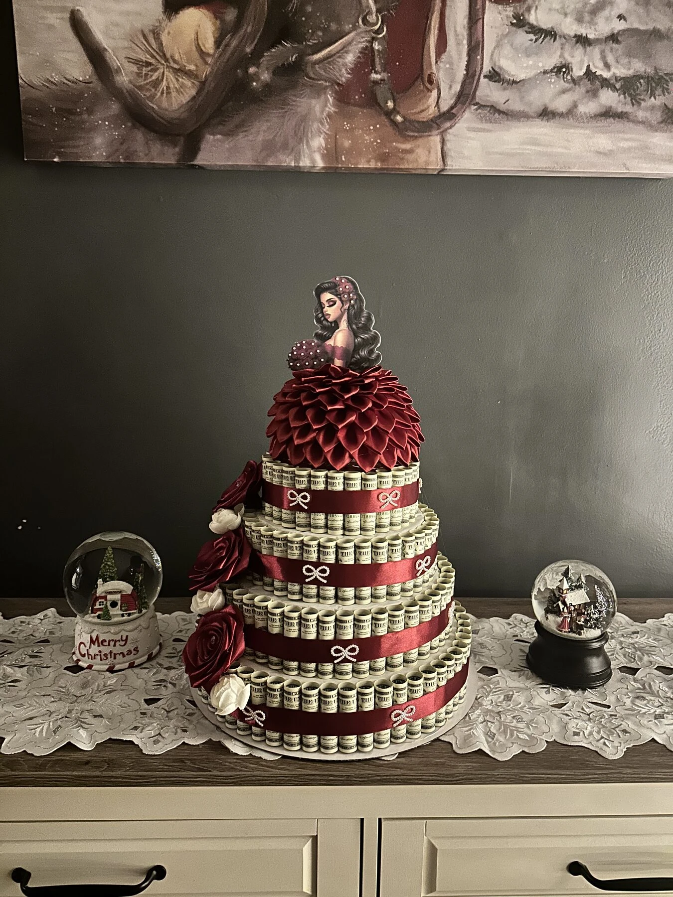 A tiered red arrangement topped with a small figure and surrounded by decorative details.
