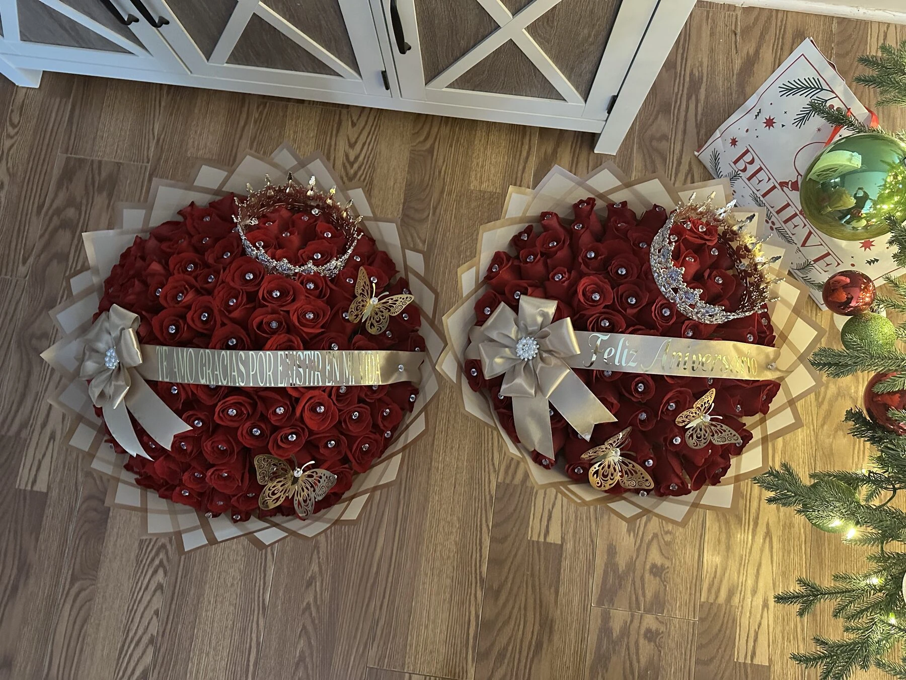 Two red round arrangements with pale ribbons displayed side by side.