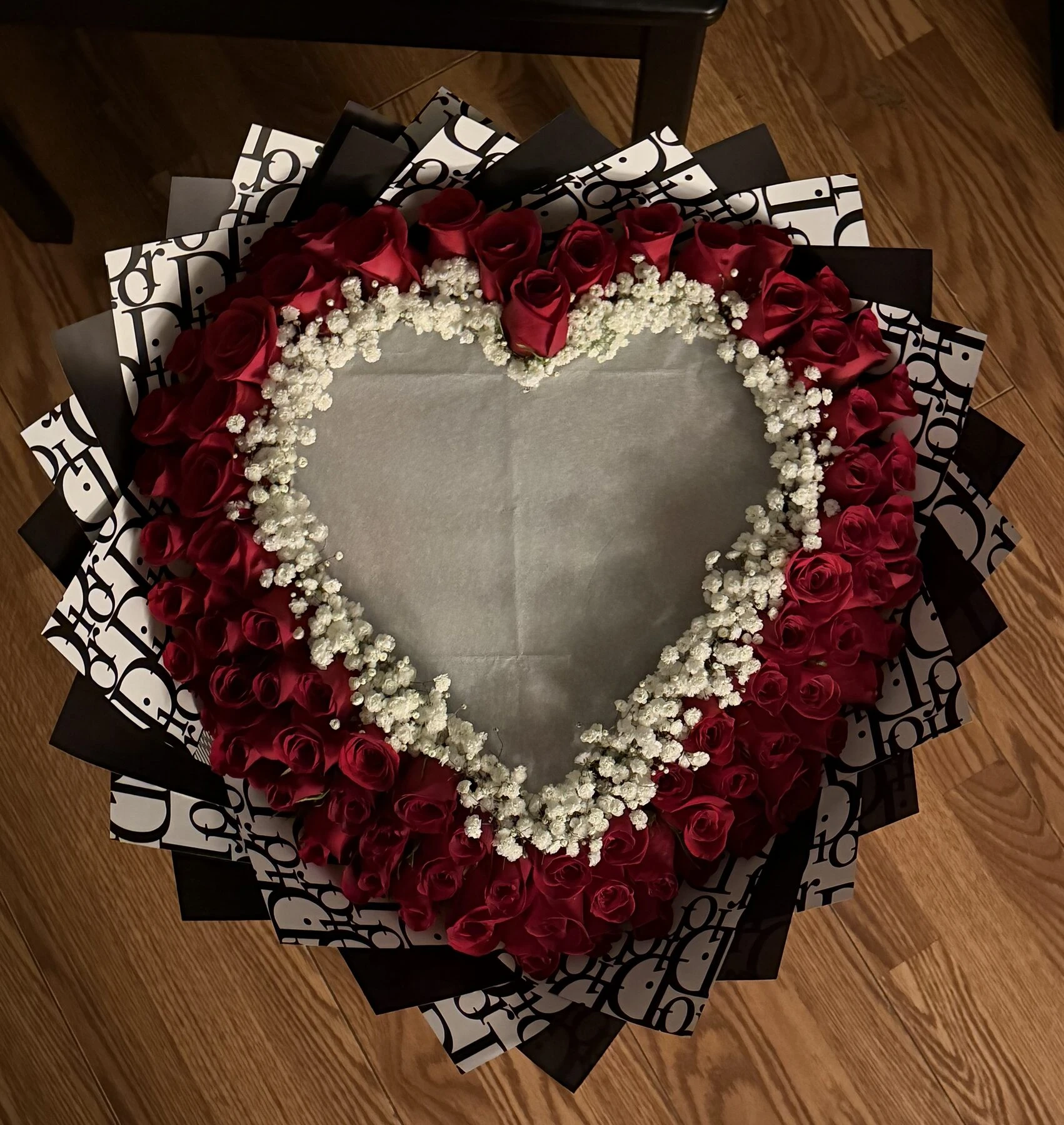 Red blooms outline a large heart-shaped center edged with small white flowers.