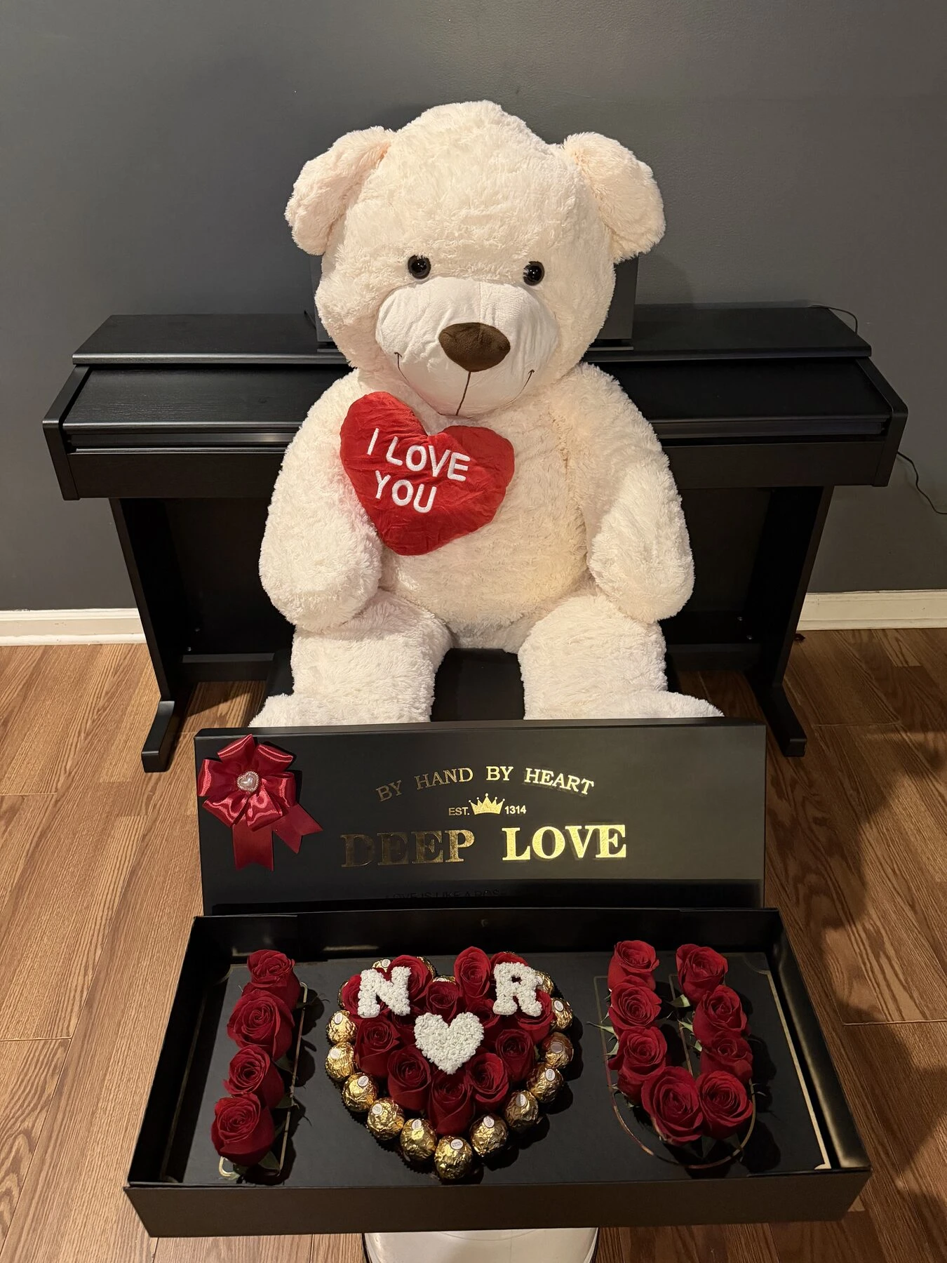 A large white plush bear displayed above an open gift arrangement.