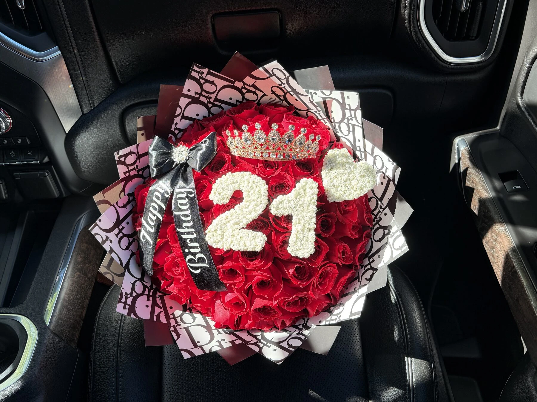 A round red floral arrangement with a large white number at the center.