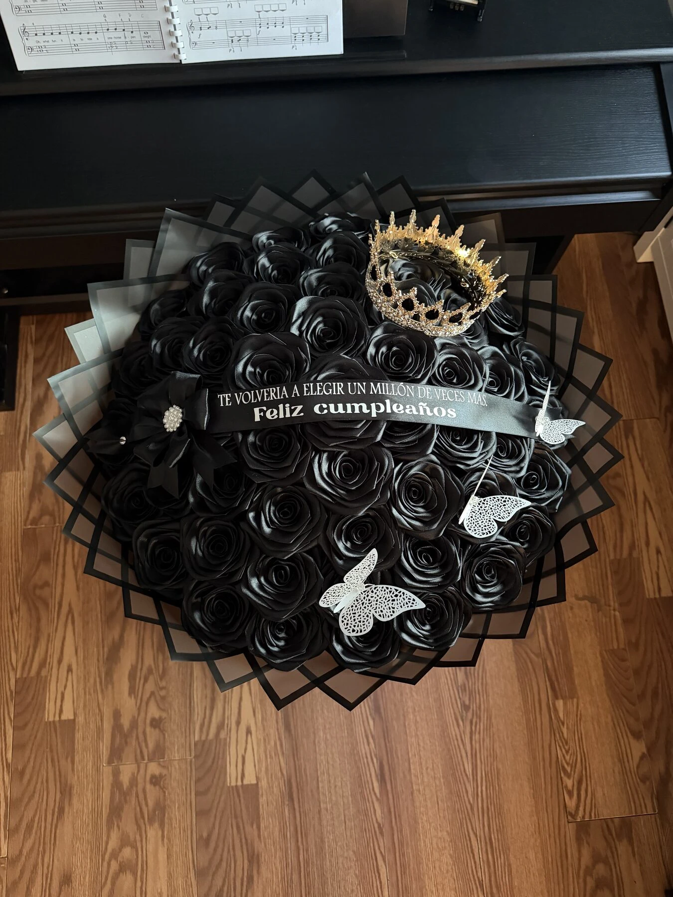 A dark arrangement of black and white rose-shaped blooms with a pale center detail.
