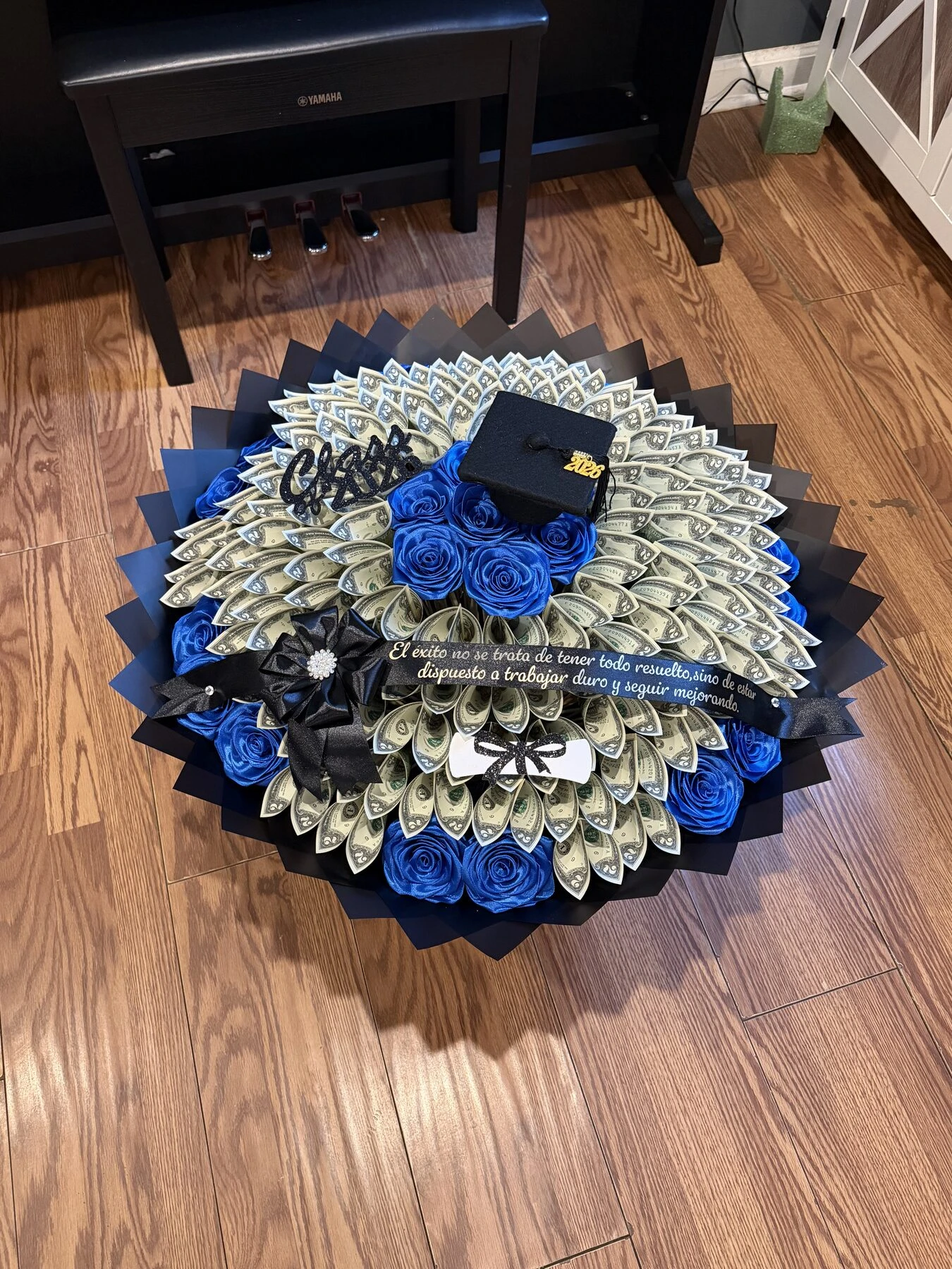 Blue blooms at the center of a round arrangement ringed with folded bills and layered wrapping.